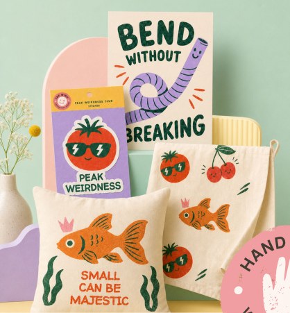 Still life of INK WINK prints, stickers, pouches and totes